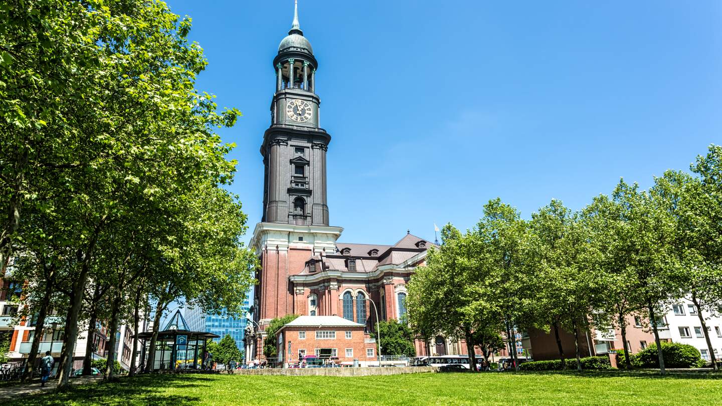 St. Michaeliskirche in Hamburg mit grüner Wiese und Bäumen | © Gettyimages.com/querbeet Kadri Oliver Alkan