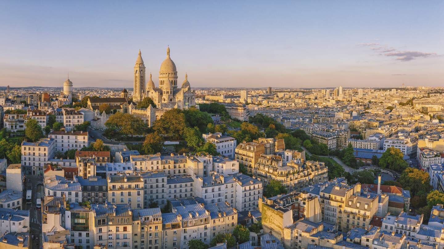 Luftaufnahme des Montmartre-Hügels mit der Basilique du Sacre-Coeur in Paris bei Sonnenuntergang | © Gettyimages.com/pawel.gaul