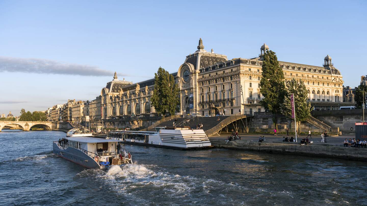 Musée d'Orsay an der Seine in Paris, ein Boot fahrend im Vordergrund auf der Seine | © Gettyimages.com/omersukrugoksu