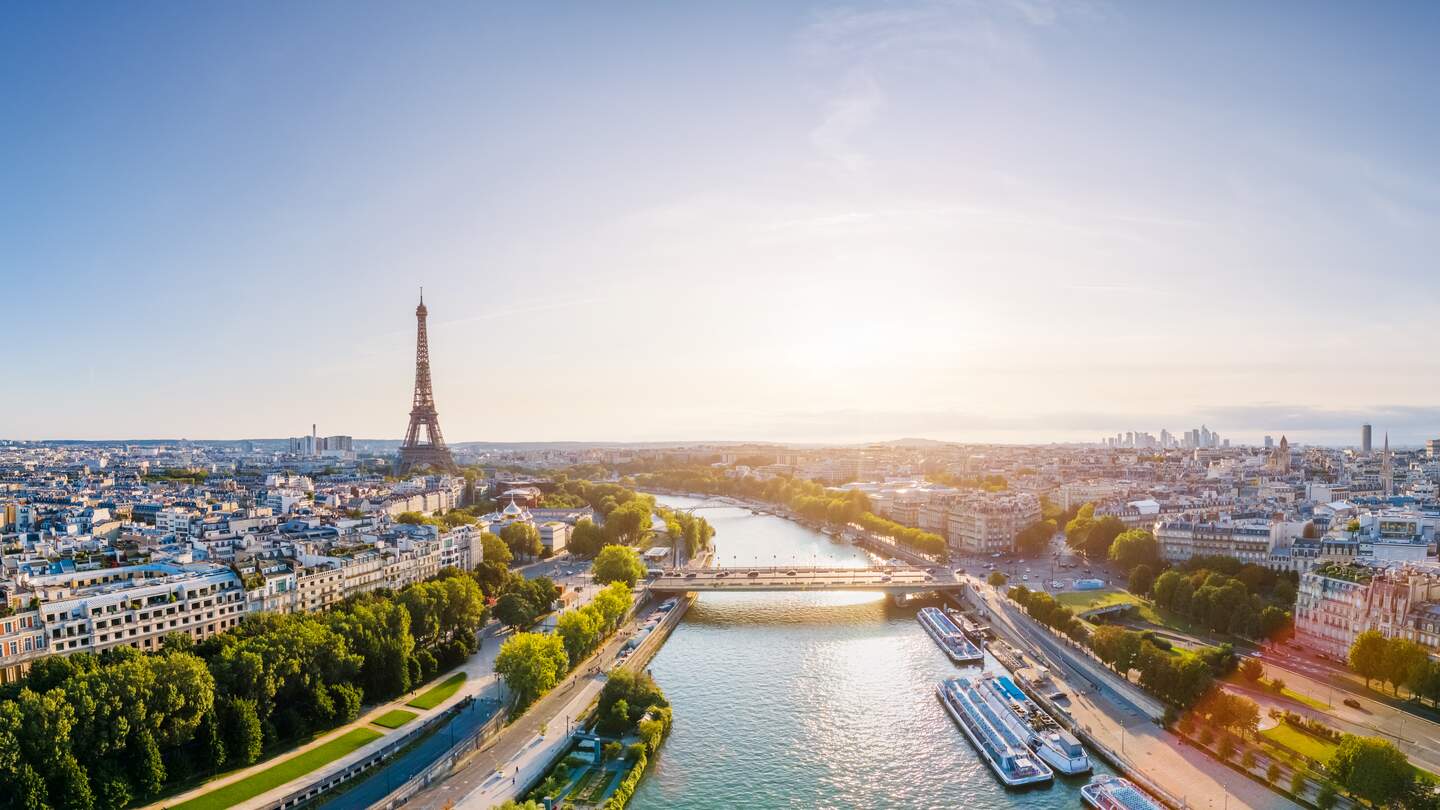 Panoramablick über historische Gebäude und Wahrzeichen mit blauem Himmel und Sonne in Paris | © Gettyimages.com/NicoElNino