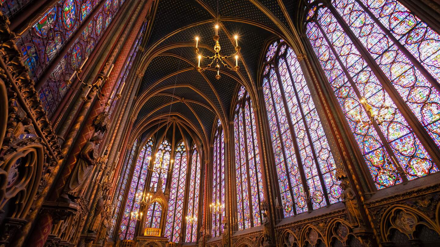 Innenraum der Kirche Sainte-Chapelle mit sehr hohen bunten Glasfenstern, eingebettet in gotische Spitzbögen. | © Gettyimages.com/neirfy