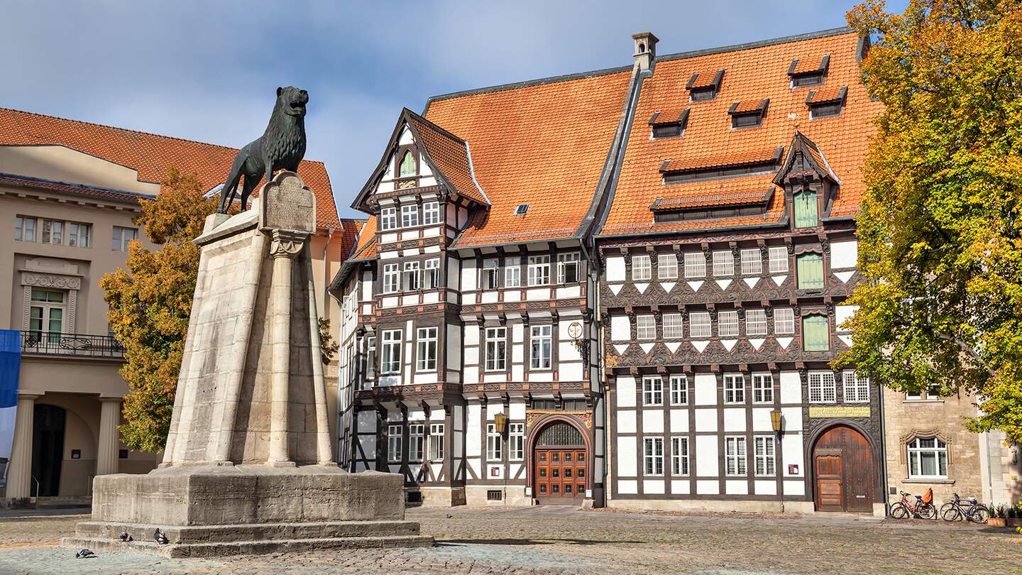 Statue von Leon und altes Fachwerkgebäude auf dem Burgplatz in Braunschweig | © GettyImages.com/bbsferrari