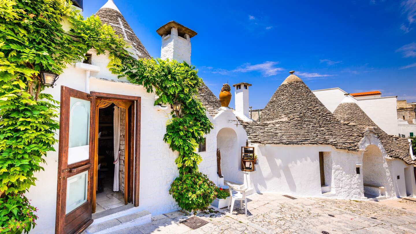 Typische weiß getünchte Trulli-Häuser mit ihren kegelförmigen Dächern der Stadt Alberobello | © Gettyimages.com/emicristea