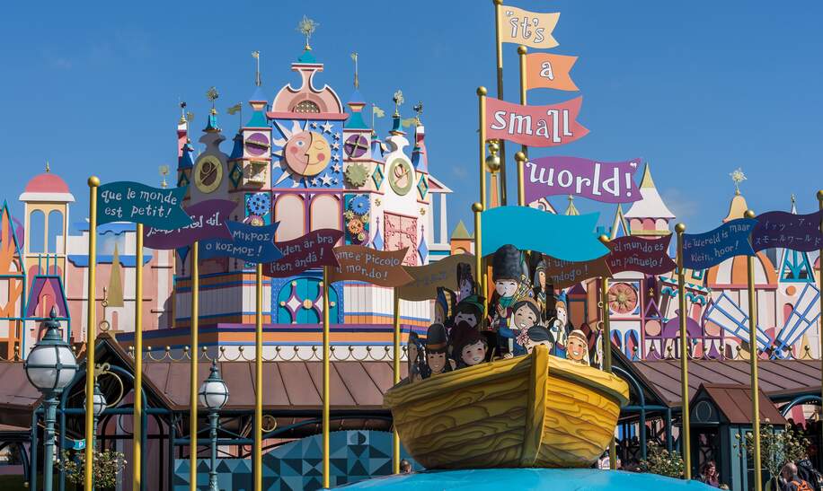 Eingang zur Attraktion Small World in Disneyland® Park mit Fahnen und Boot | © Disney