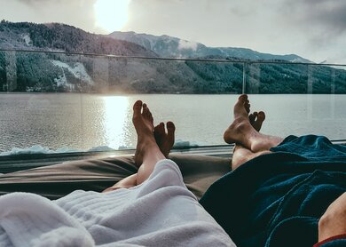 Paar entspannt auf den Sonnenliegen im Spa, wobei nur ihre Beine sichtbar sind | © Gettyimages.com/Christopher Moswitzer