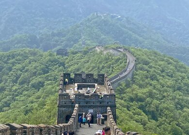 Menschen wandern auf der Großen Mauer bei Peking in China mit Blick auf Grüne Hügel und Wachtürme | © J-Navigator Foto-Archiv
