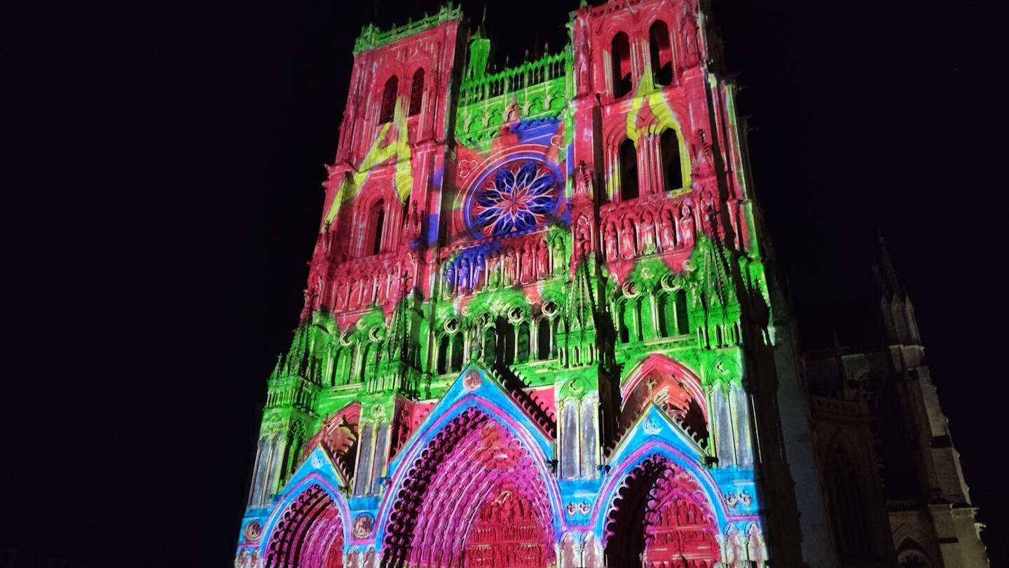 Die farbig illuminierte Fassade der Kathedrale am Abend in Amiens, Frankreich | © Jens Hinsche