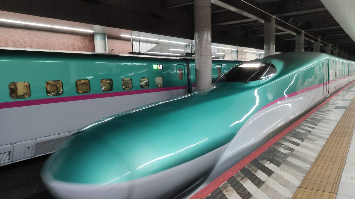 Der futuristische Shinkansen Superespress Zug steht auf einem Gleis in einem Bahnhof | © Jens Hinsche