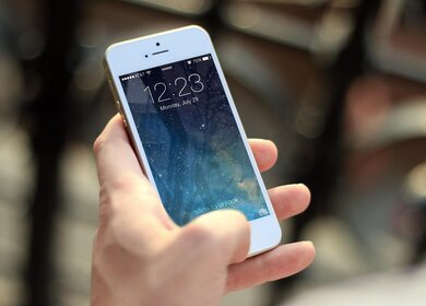 Nachtzug Reise Tipp: Wecker stellen für einen entspannten Morgen. Dargestellt durch ein Smartphone, das eine Person in der Hand hält. Der Bildschirmhintergrund zeigt einen Nachthimmel mit vielen leuchtenden Sternen. | © Pixabay/JESHOOTS-com