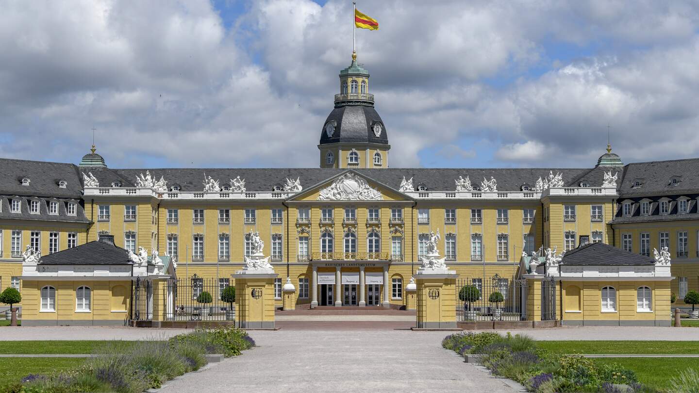 Blick auf die Fassade des Karlsruher Schlosses bel blauem Himmel mit leichten weißen Wölkchen | © KTG Karlsruhe Tourismus GmbH/Fabian von Poser