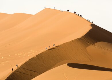 Tourist klettert auf eine Sanddüne in Sossusvlei.  | © Gettyimages.com/2630ben