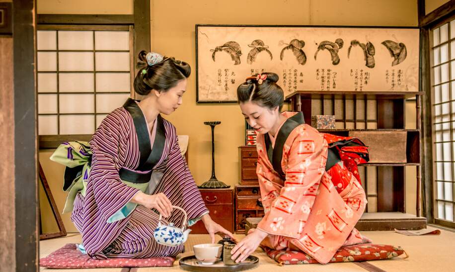 Zwei Frauen in traditionellen Kimonos fuehren eine japanische Teezeremonie in einem klassischen Tatami-Raum durch. | © gettyimages.com/Ababsolutum
