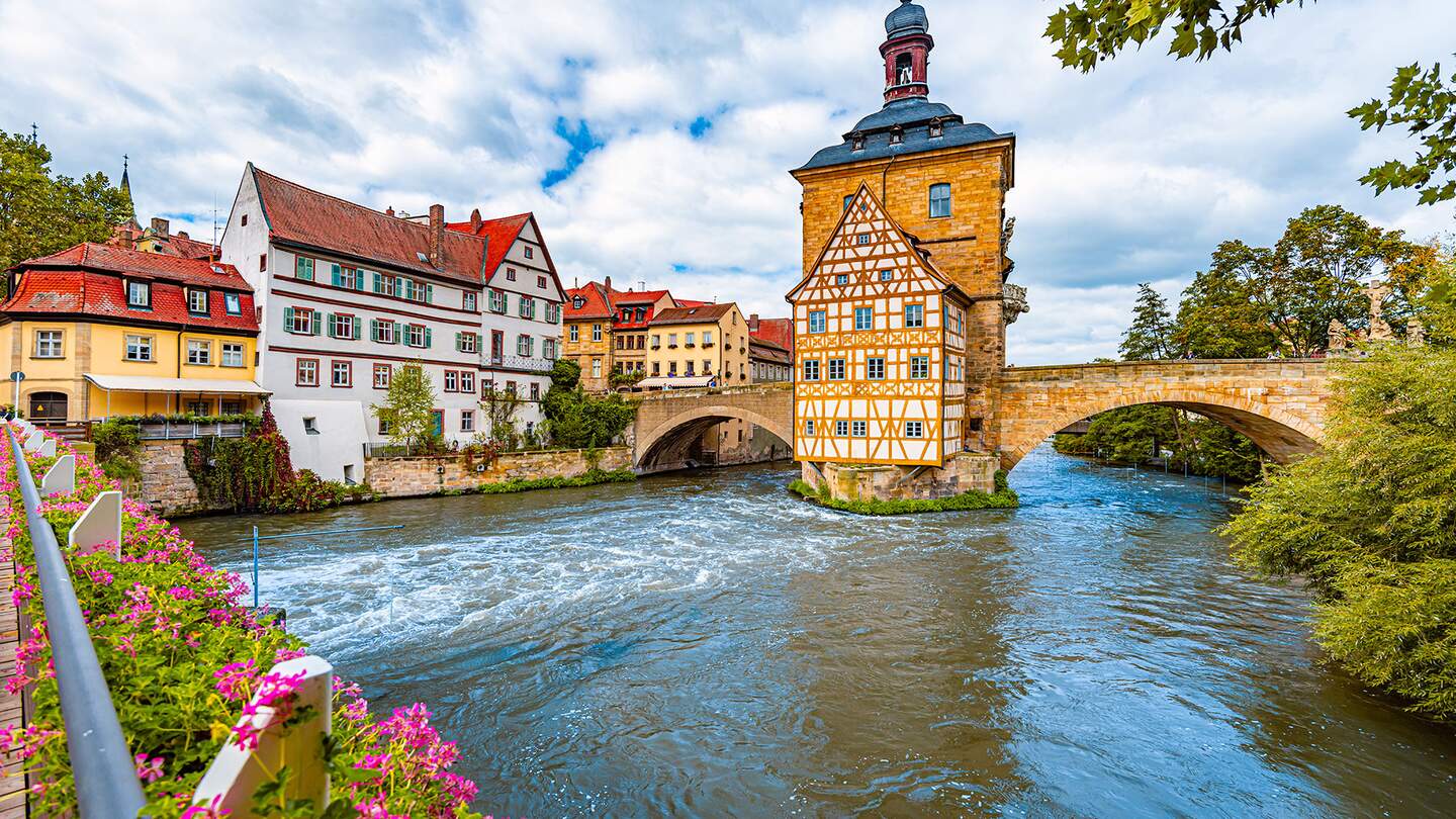 Blick auf das Rathaus über der Regnitz und die Fachwerkarchitektur der Altstadt in Bamberg | © Gettyimages.com/kyolshin
