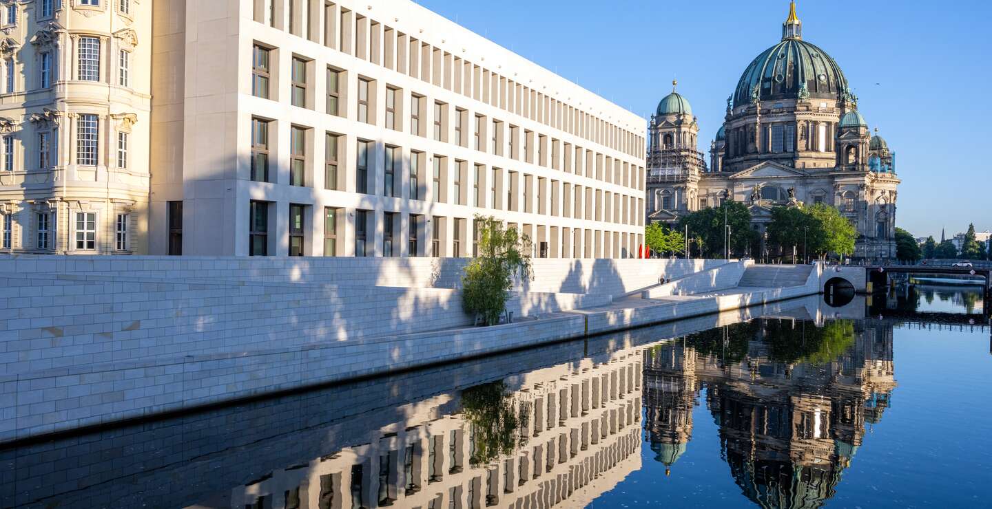 Das wiederaugebaute Berliner Stadtschloss auf dem Humboldt Forum mit dem Dom, der sich in der Spree spiegelt | © Gettyimages.com/elxeneize