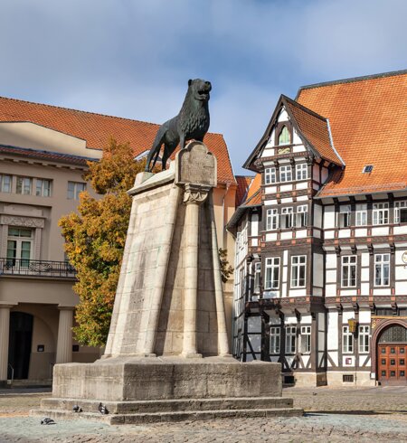 Statue von Leon und altes Fachwerkgebäude auf dem Burgplatz in Braunschweig | © GettyImages.com/bbsferrari