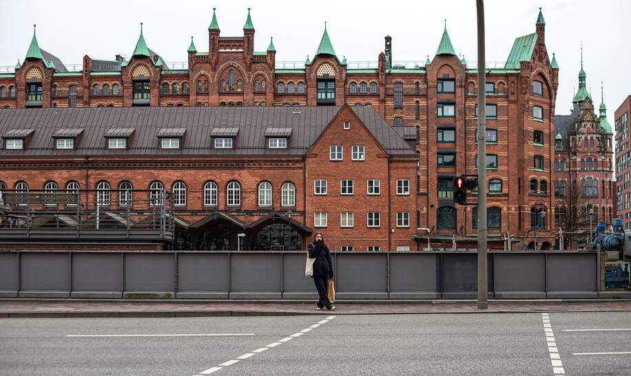 Hamburg Speicherstadt mit einer Frau vor einem Backsteingebäude | © Gettyimages.com/puhimec
