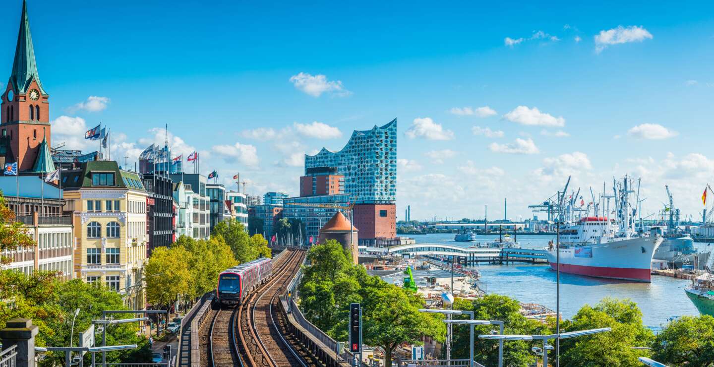 Panoramablick über die Uferpromenade im Zentrum Hamburgs, von den Landungsbrückenvillen über das ikonische Gebäude der Elbphilharmonie bis zu den Schiffen im geschäftigen Hafen des Hamburger Hafens | ©  Gettyimage.com/fotoVoyager