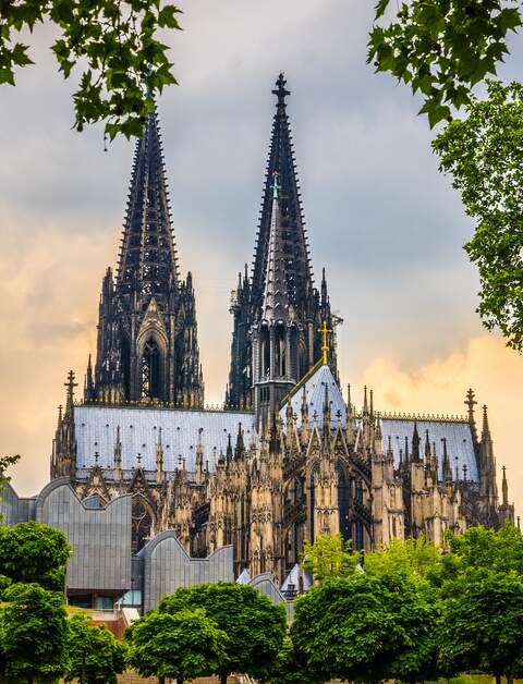Kölner Dom in Köln, aufgenommen vom Fuße des Doms mit Bäumen im Vordergrund | © Gettyimages.com/Jan de Waal