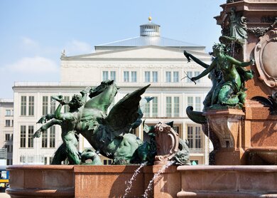 Detail des berühmten Mende-Brunnens in Leipzig. Leipziger Opernhaus im Hintergrund. | © Gettyimages.com/TommL
