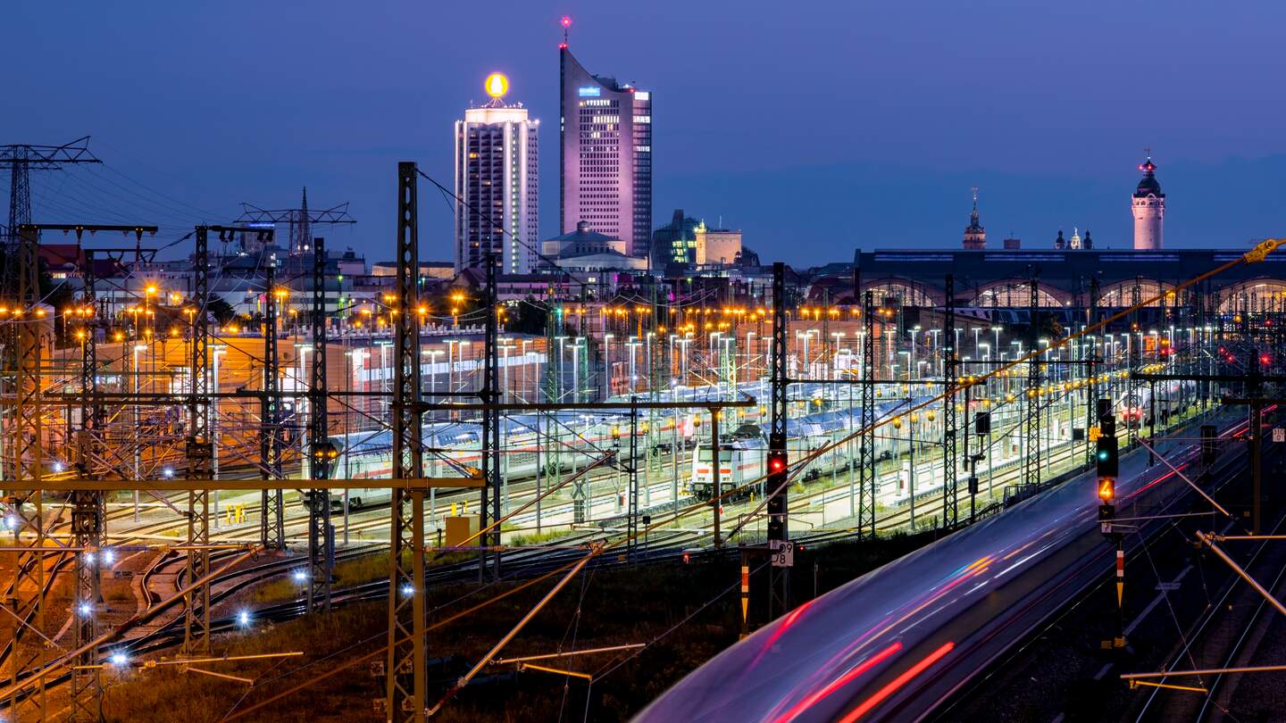 Langzeitbelichtung mit beleuchtetem Stadtbild, Wolkenkratzern, Hauptbahnhof und einfahrendem Zug. | © Gettyimages.com/marcusfriedrich