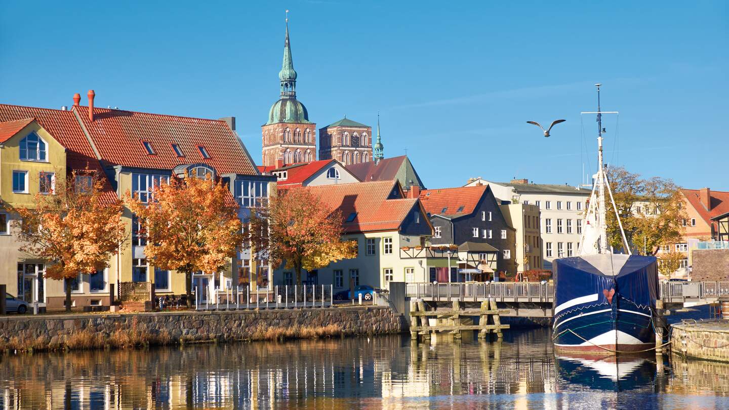 Angedockte Segelboote und Häuser im Kanal mit Backsteintürme Stralsund | © © Gettyimages.com/anyaivanova