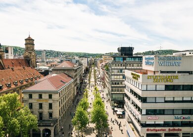Luftaufnahme der Königsstrasse in Stuttgart. Unten laufen Passanten an einem herrlichen Sommertag.   | © © Gettyimages.com/nullplus
