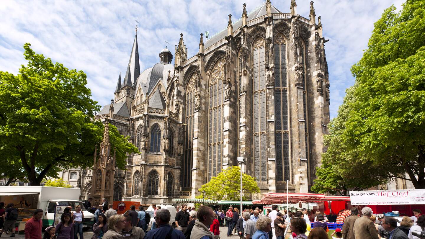 Menschen auf einem Bauernmarkt vor dem Aachener Dom | © Gettyimages.com/eyewave