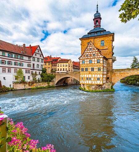 Blick auf das Rathaus über der Regnitz und die Fachwerkarchitektur der Altstadt in Bamberg | © Gettyimages.com/kyolshin