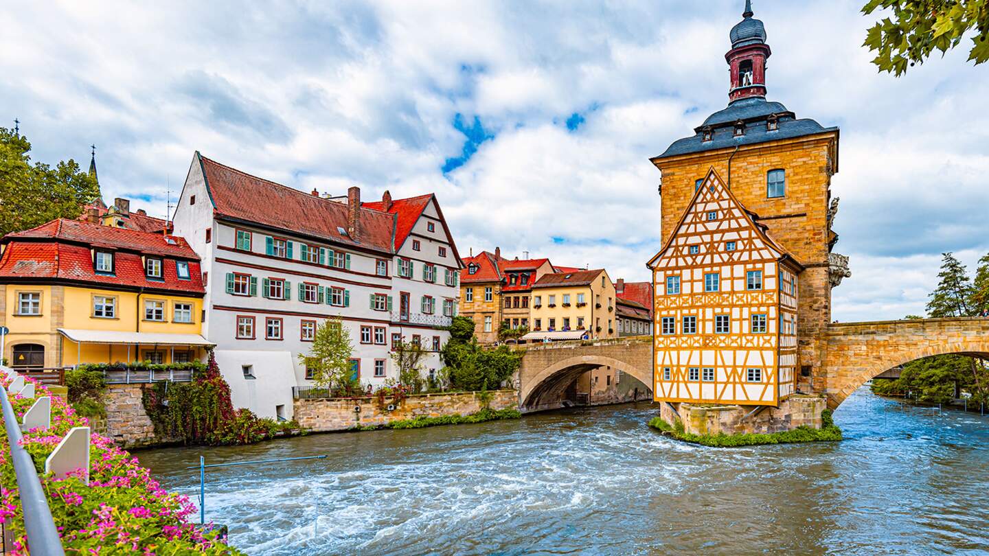 Blick auf das Rathaus über der Regnitz und die Fachwerkarchitektur der Altstadt in Bamberg | © Gettyimages.com/kyolshin