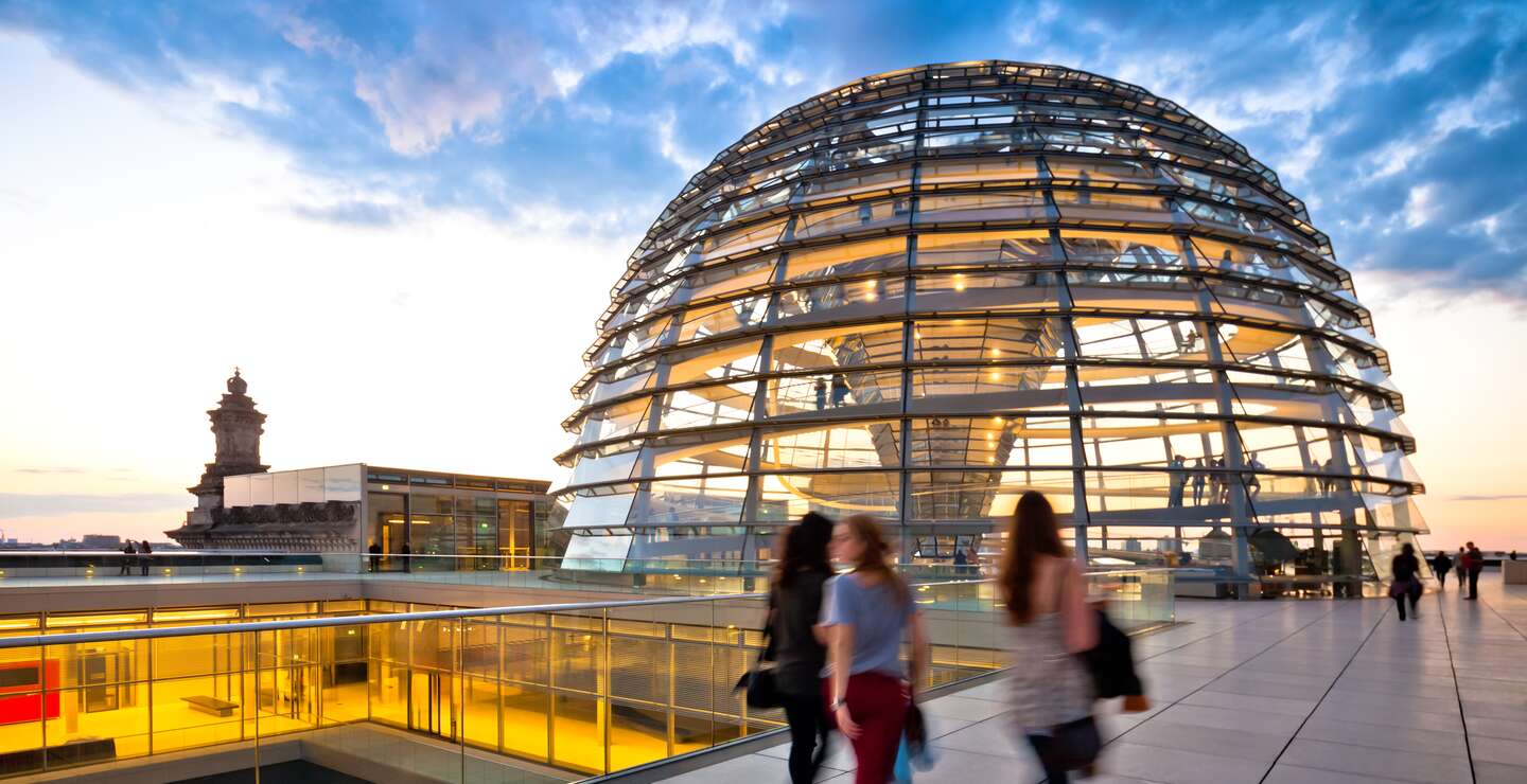 Junge Besucher auf der Aussichtsterrasse der Reichstagskuppel bei Sonnenuntergang | © Gettyimages.com/Nikada