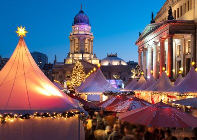 Weihnachtsmarkt am Gendarmenmarkt in Berlin Mitte. Der Deutsche Dom im Hintergrund und das Konzerthaus auf der rechten Seite. | © Gettyimages.com/mkrberlin
