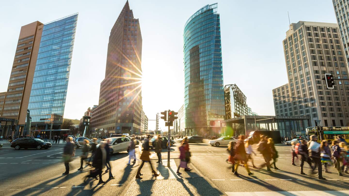 Potsdamer Platz in Berlin bei Sonnenschein. Viele Menschen überqueren eine Straße. | © Gettyimages.com/querbeet