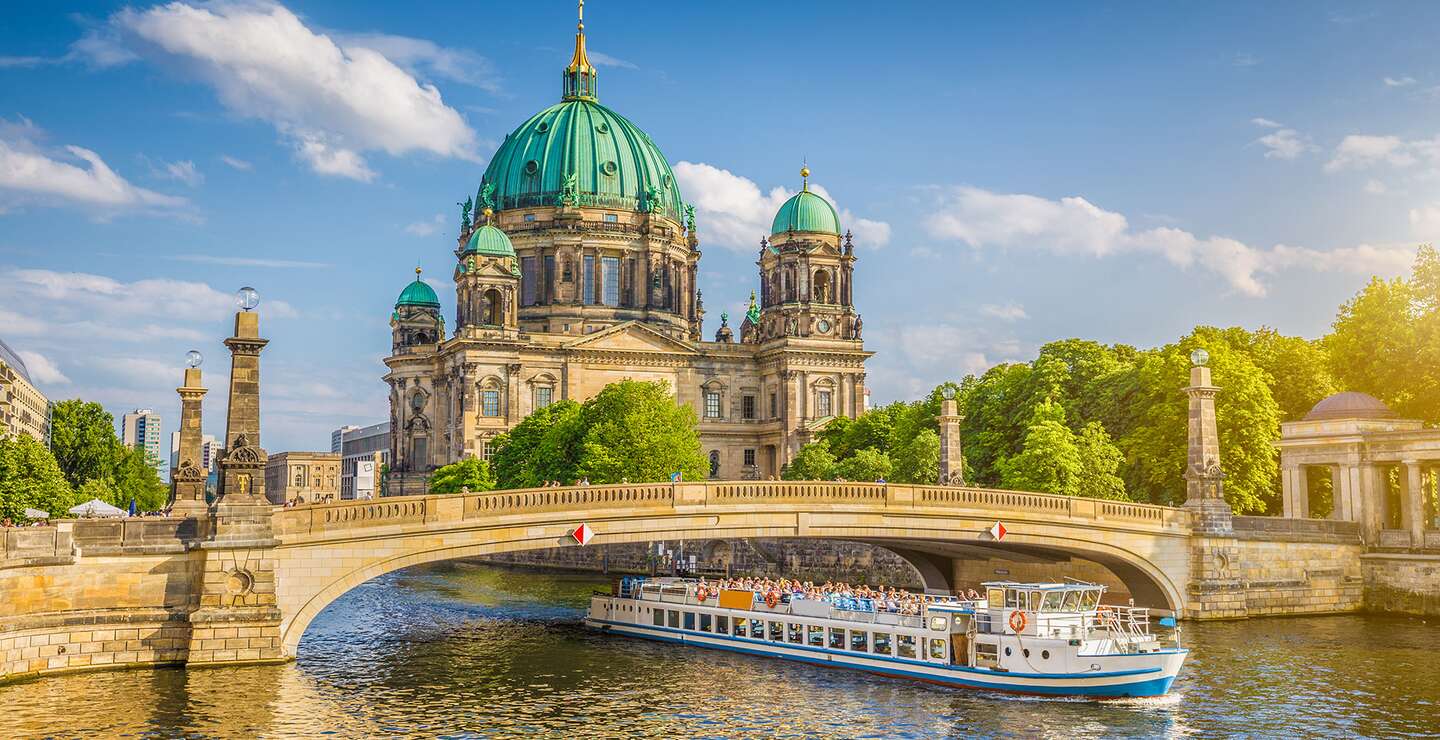 Berliner Dom an der Spree mit Schiff, dass unter der einer Brücke fährt | © Gettyimages.com/JR Photography