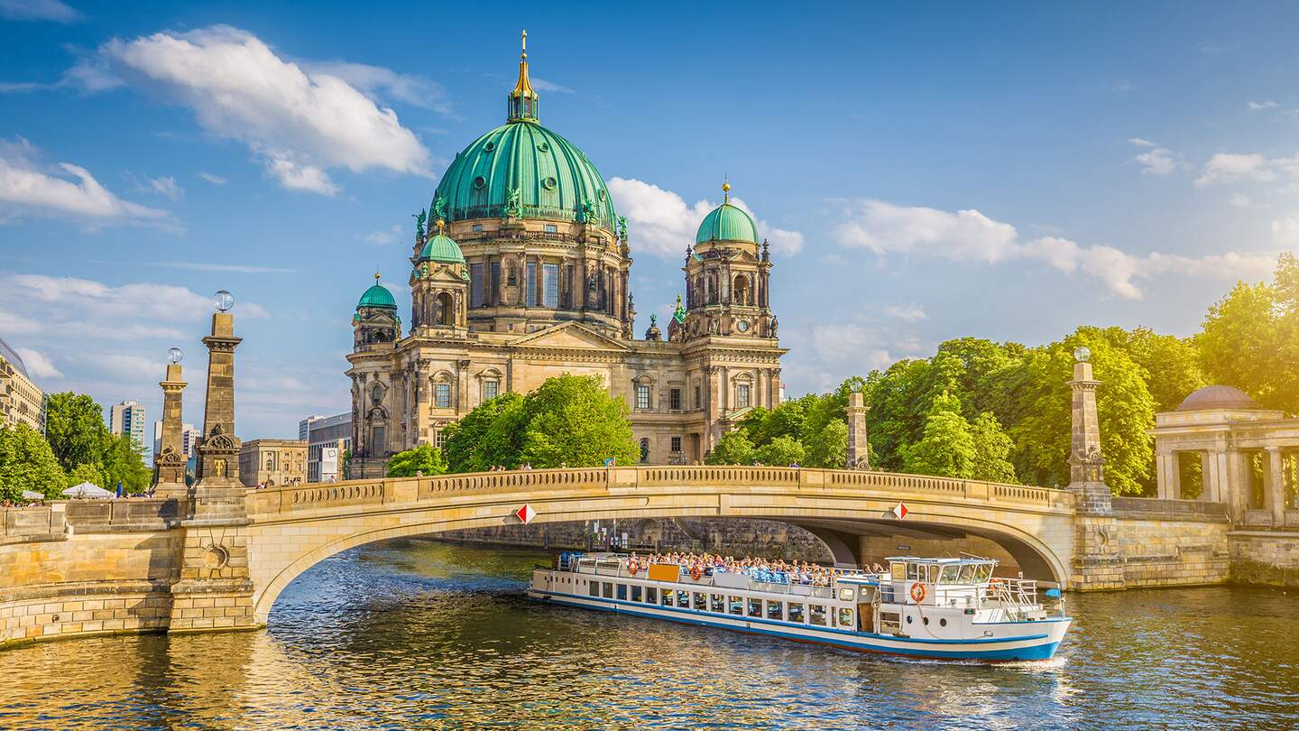 Berliner Dom an der Spree mit Schiff, dass unter der einer Brücke fährt | © Gettyimages.com/JR Photography