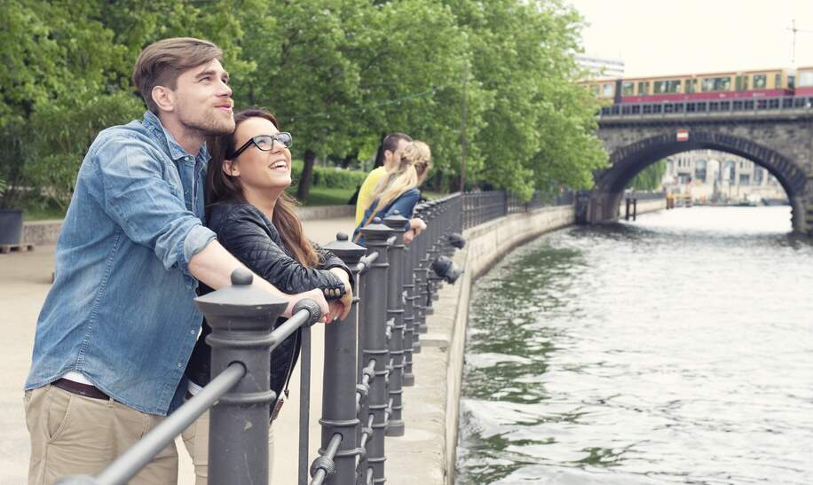 Paar an der Spree in Berlin schaut sich etwas auf der anderen Seite an | © Gettyimages.com/freie-kreation