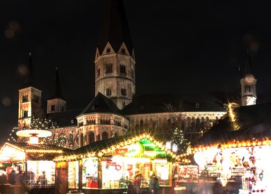 Beleuchteter Weihnachtsmarkt am Muenster in Bonn bei Nacht | © Gettyimages.com/mathess