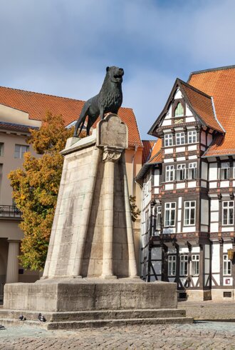 Statue von Leon und altes Fachwerkgebäude auf dem Burgplatz in Braunschweig | © GettyImages.com/bbsferrari