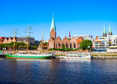 Blick auf Weser Flussufer in Bremen mit Booten und Altstadt im Hintergrund | © Gettyimages.com/saiko3p