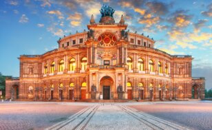Frontansicht der Semperoper Dresden am Theaterplatz in abendlich festlicher Beleuchtung | © Gettyimages.com/TomasSereda