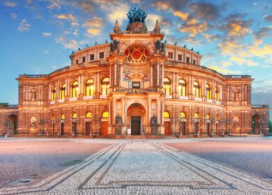 Frontansicht der Semperoper Dresden am Theaterplatz in abendlich festlicher Beleuchtung | © Gettyimages.com/TomasSereda