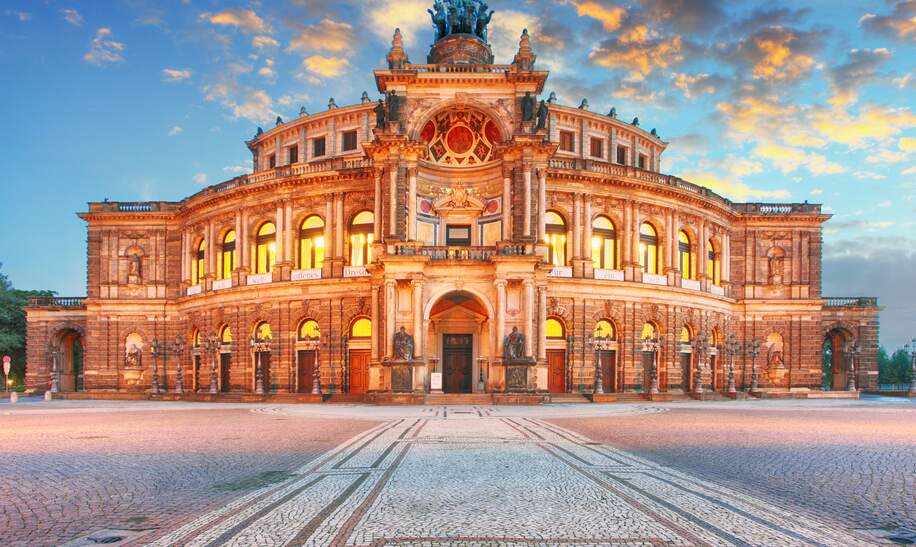 Frontansicht der Semperoper Dresden am Theaterplatz in abendlich festlicher Beleuchtung | © Gettyimages.com/TomasSereda