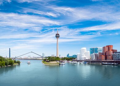 Panorama von Duesseldorfer Medienhafen mit Rheinturm und moderner Architektur bei blauem Himmel | © GettyImages.com/jotily