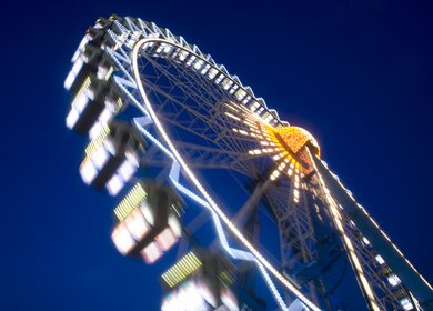 Riesenrad dreht sich in der Nacht in Frankfurt am Main bei der lokalen Veranstaltung Dippemess. | © Gettyimages.com/kontrast-fotodesign