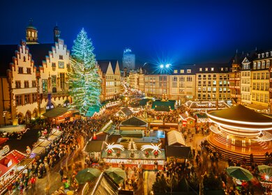 Traditioneller Weihnachtsmarkt in Frankfurt am Roemer mit beleuchtetem Weihnachtsbaum und vielen Staenden | © Gettyimages.com/sborisov