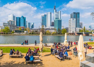 Viele Menschen sitzen in einem Cafe im Freien am Mainufer von Frankfurt | © Gettyimages.com/fotoVoyager