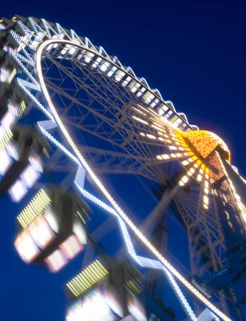 Riesenrad dreht sich in der Nacht in Frankfurt am Main bei der lokalen Veranstaltung Dippemess. | © Gettyimages.com/kontrast-fotodesign