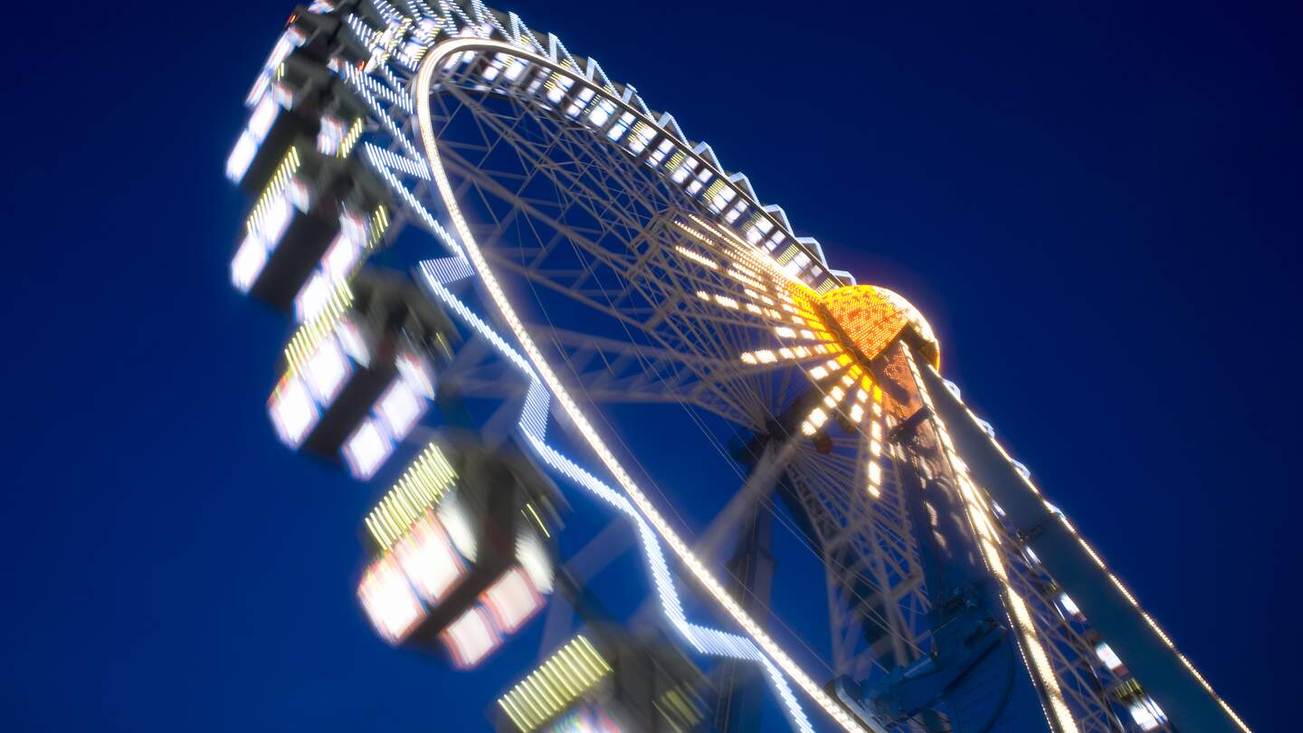 Riesenrad dreht sich in der Nacht in Frankfurt am Main bei der lokalen Veranstaltung Dippemess. | © Gettyimages.com/kontrast-fotodesign