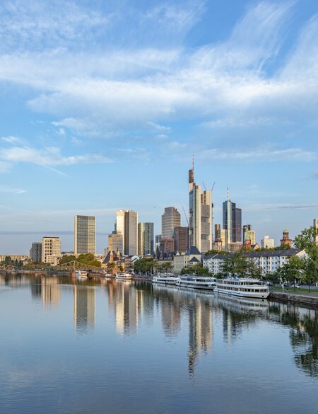 Stadtbild der Skyline von Frankfurt mit Blick auf den Main mit hellblauem Himmel | © Gettyimages.com/travelview