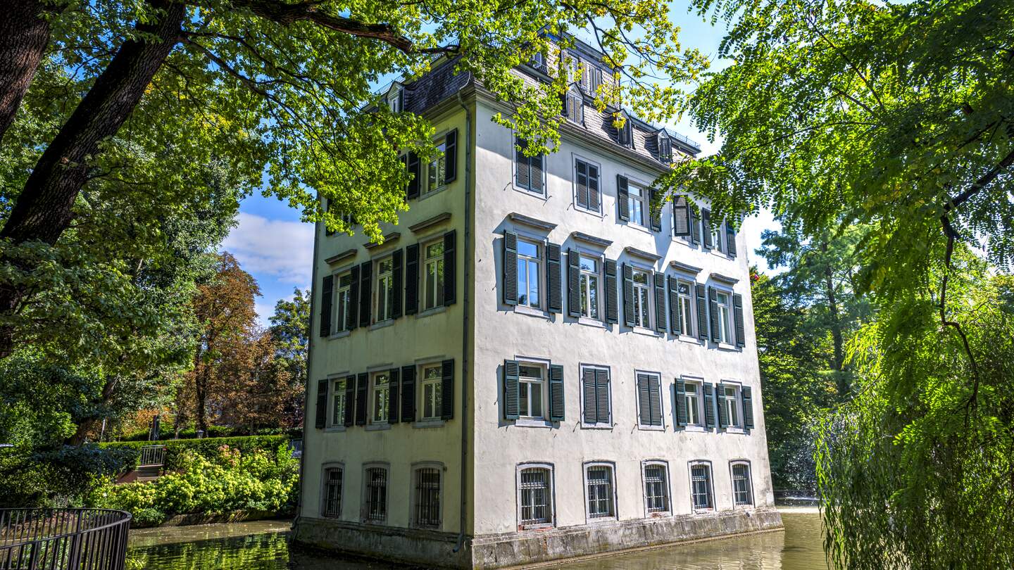 Das Holzhausenschloesschen in Frankfurt am Main im fruehen Hebst mit vielen Baeumen  | © Gettyimages.com/Frank Wagner