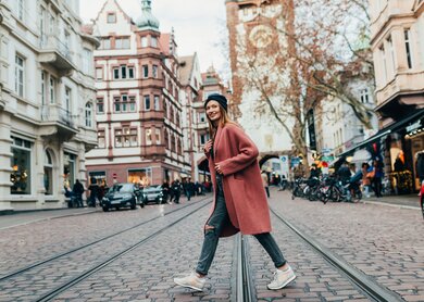Eine Ost-Europaeische Frau laeuft ueber die Gleise einer Strassenbahn in Freiburg | © GettyImages.com/Drazen_